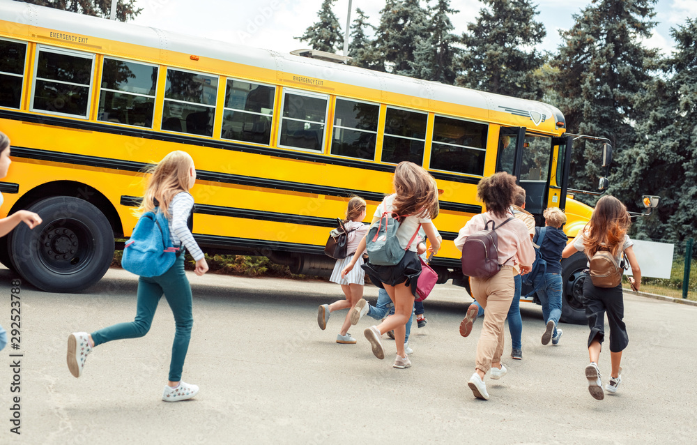 Classmates running to school bus back view late. School bus safety tips