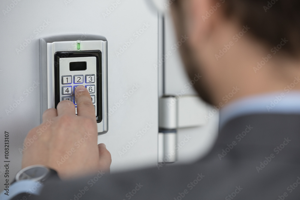 Close up of businessman hand entering security system code. Access Control Systems