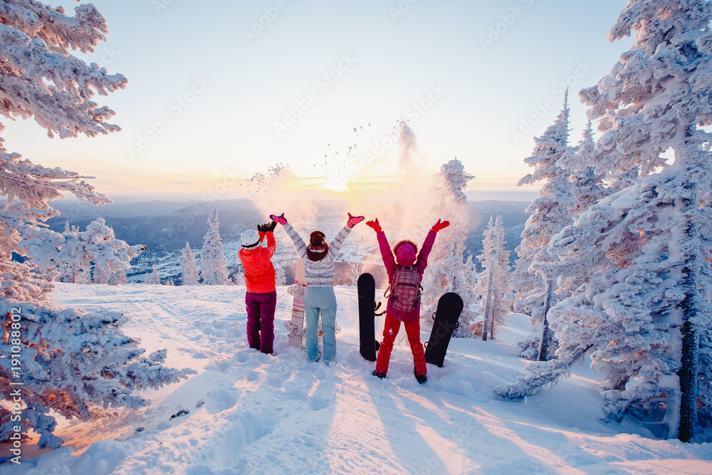 Happy team of snowboarders having fun tossing snow and fun. Securing Your Home During Winter Vacation