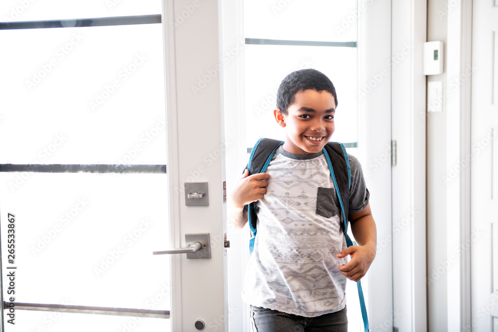 A child boy coming home passing through the door after school. staying home alone