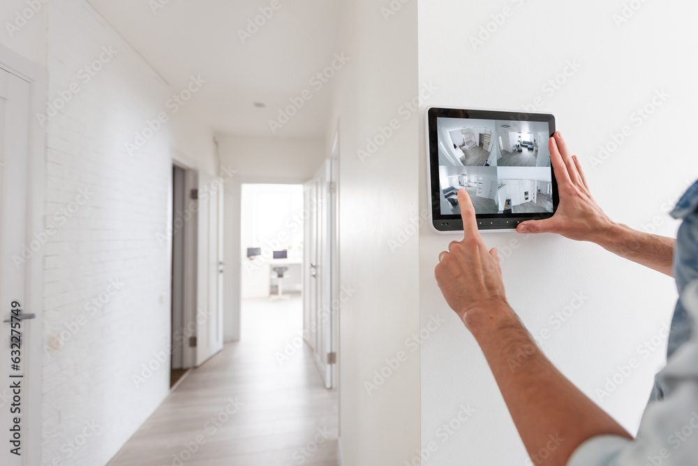 Augmented reality concept. Hand holding tablet with AR application used to simulate furniture and design products in an interior construction site, modern kitchen with Island, 3d illustration. Home security products