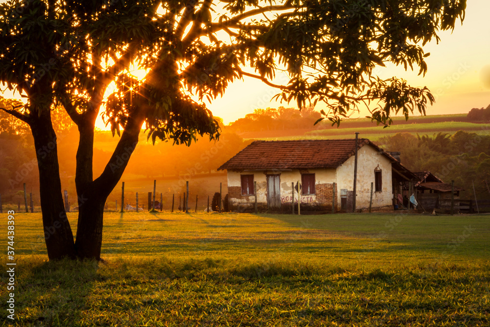 orange sunset on the farm with old house farm security