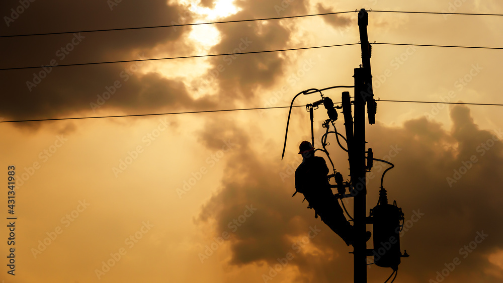 The silhouette of power lineman climbing on an electric pole with a transformer installed. And replacing the damaged hotline clamp, bail clamp, dropout and surge arrester that causes a power failure. Safety during power outages