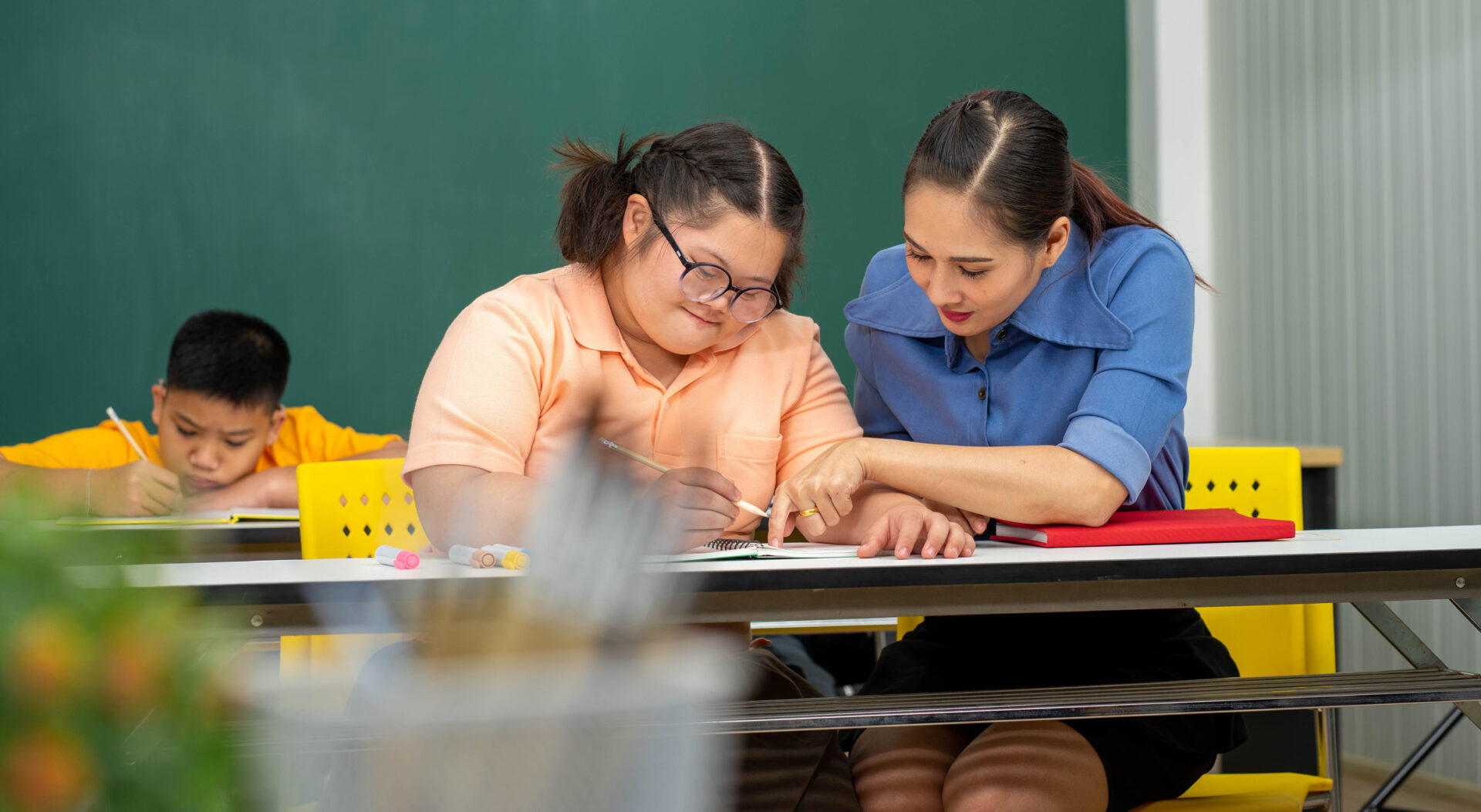 Teacher helping student in classroom