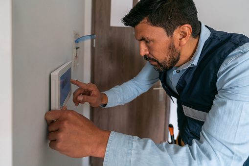 Man adjusting home security system panel