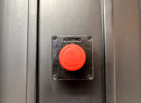 Safety button mounted on metal surface