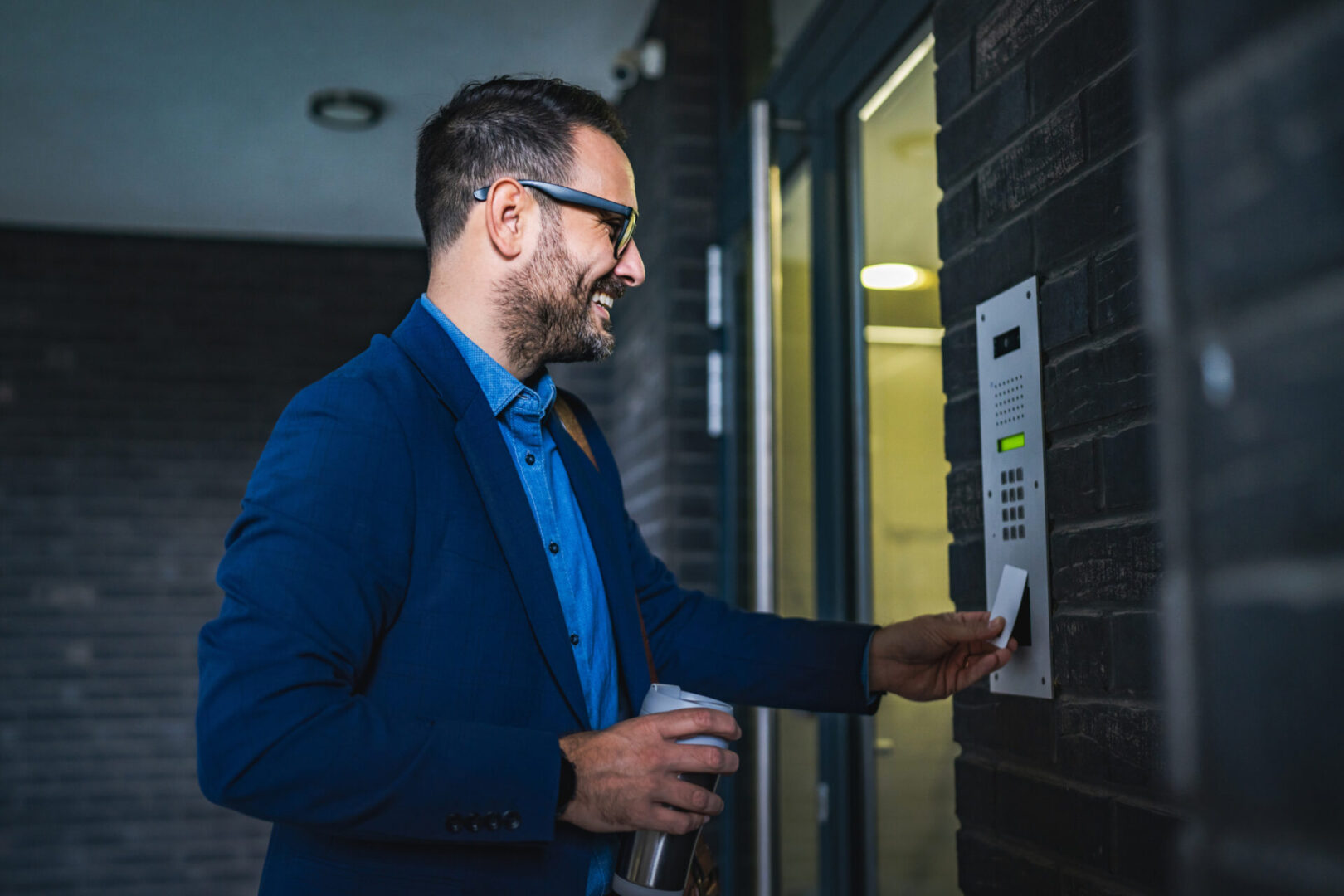 Smiling man accessing secure entry panel