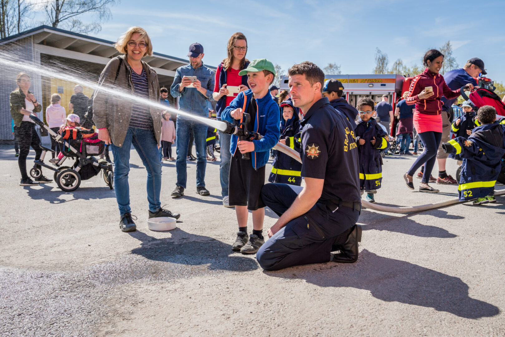 Children using fire hose at event