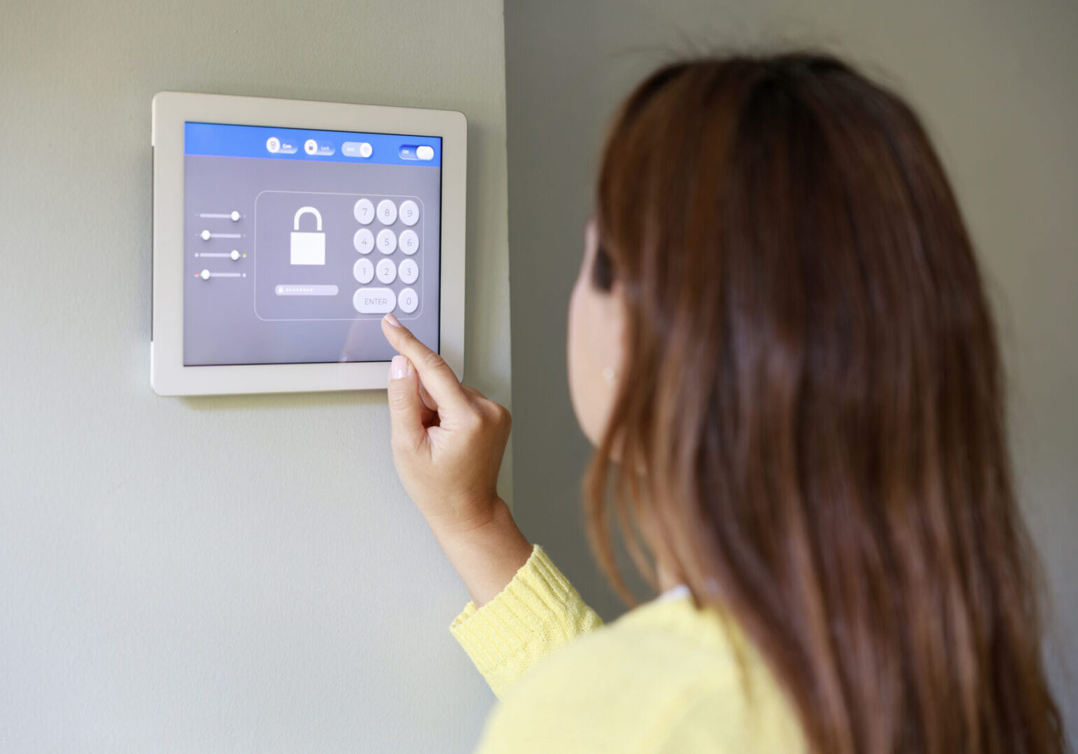 Woman entering code on a home security keypad.