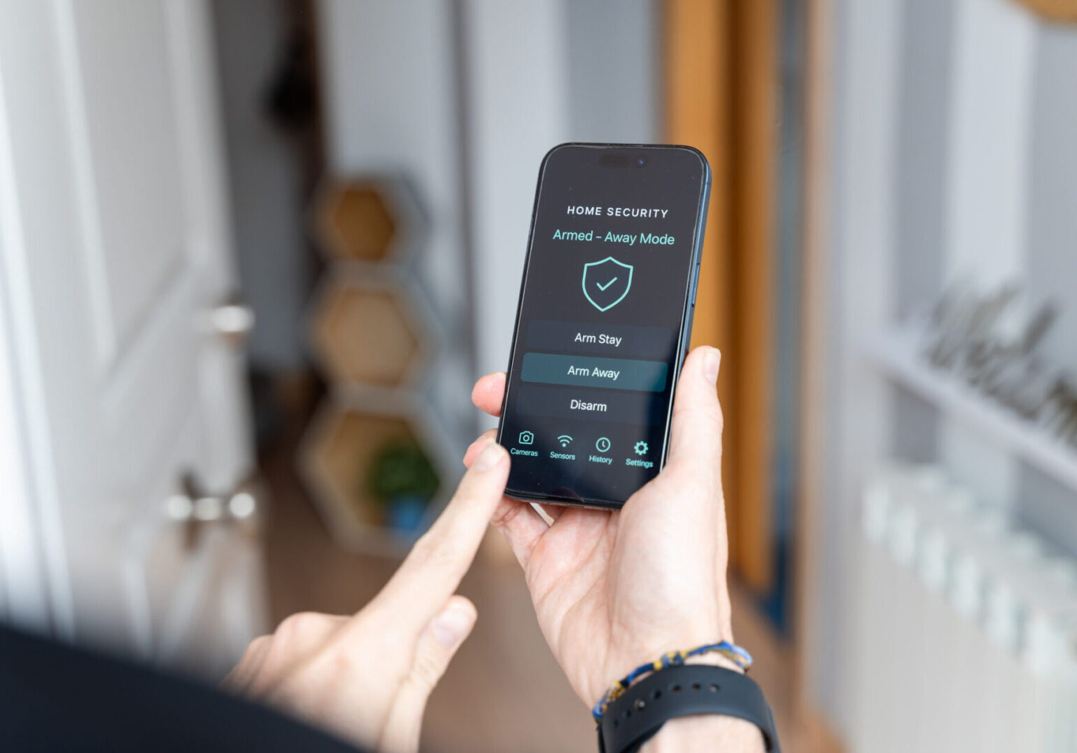 Homeowner using a smartphone app to activate the security system, ensuring peace of mind while away