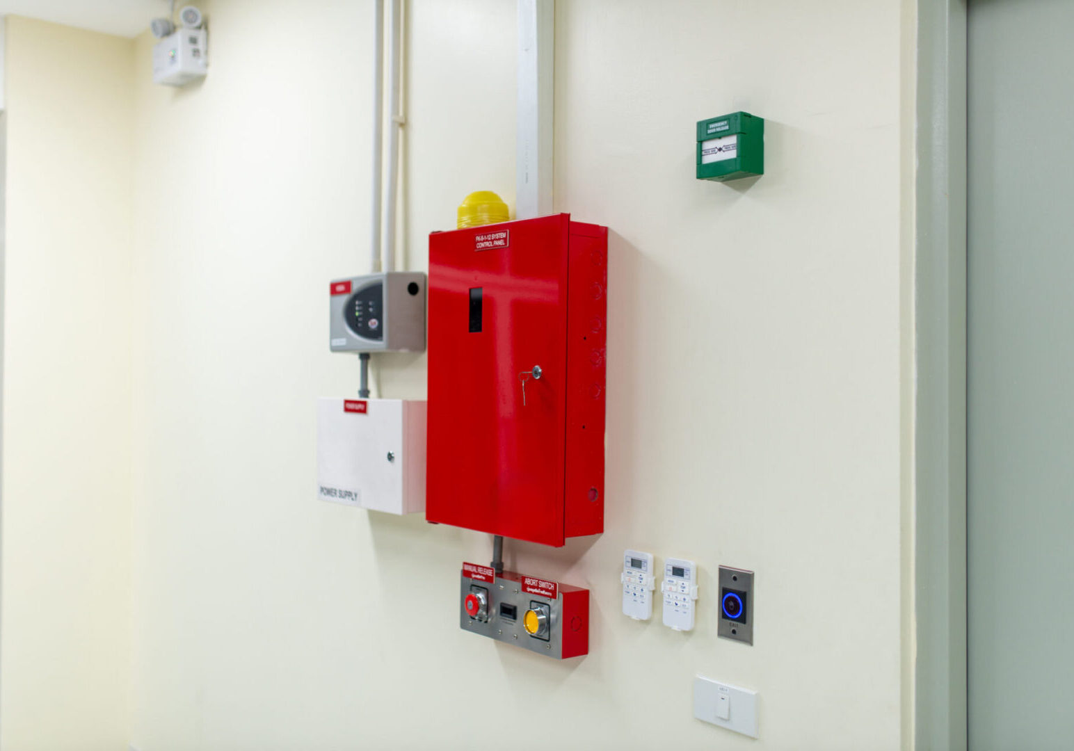 Wall-mounted fire safety equipment including a red fire extinguisher cabinet.